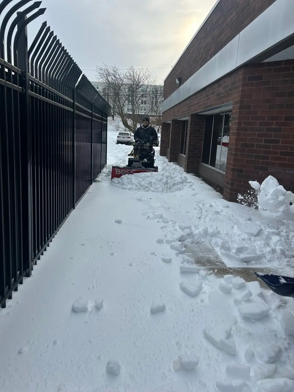 Worker clearing snow with a snow blower